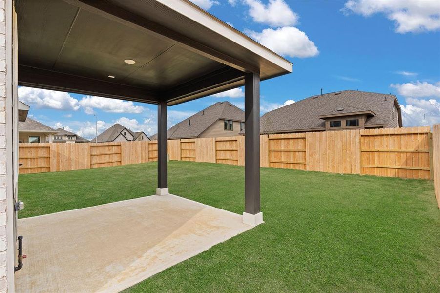 The covered patio is generously sized, providing ample space for various outdoor activities.