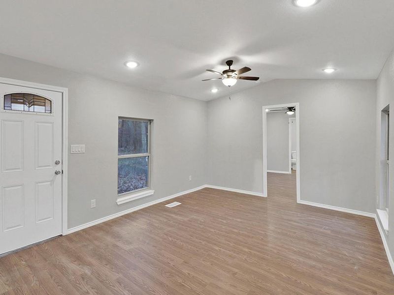 Entrance foyer with light hardwood / wood-style flooring, vaulted ceiling, and ceiling fan