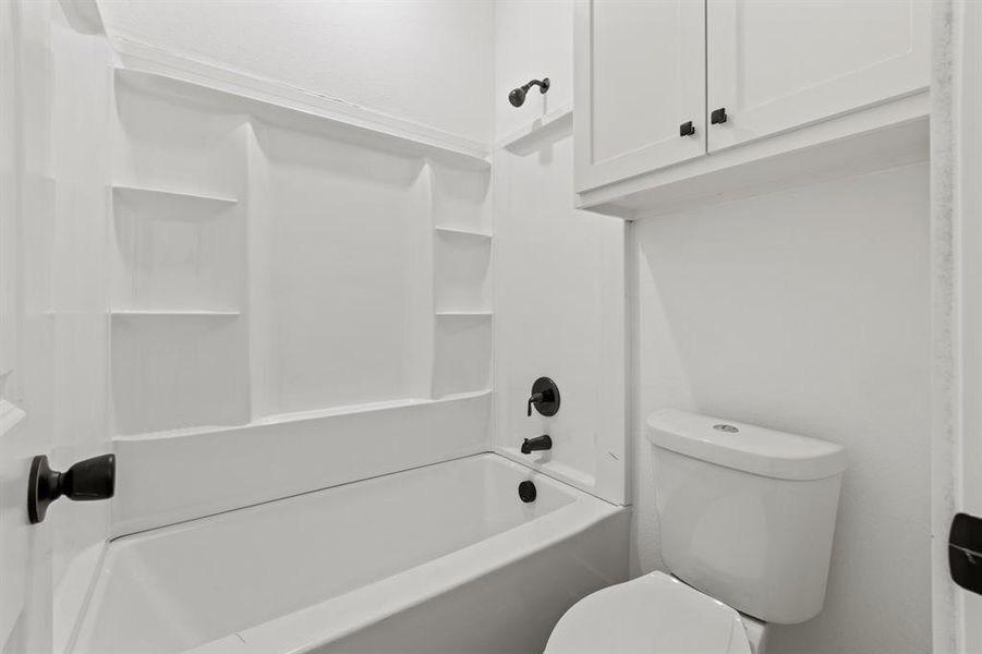 Bathroom featuring toilet and shower / bathing tub combination