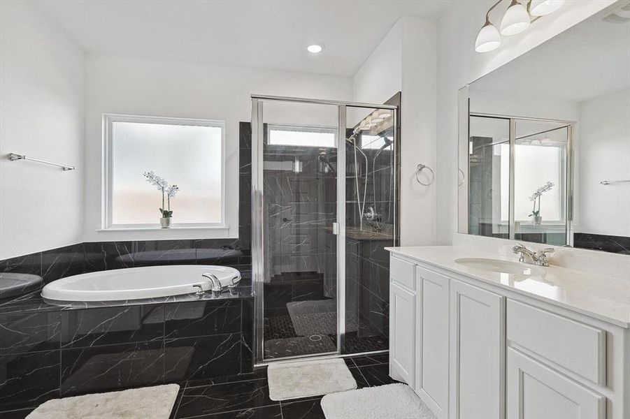 Bathroom with vanity and shower with separate bathtub