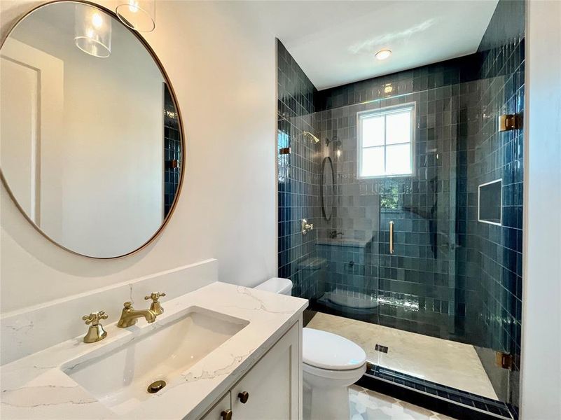 Bathroom featuring vanity, toilet, and an enclosed shower