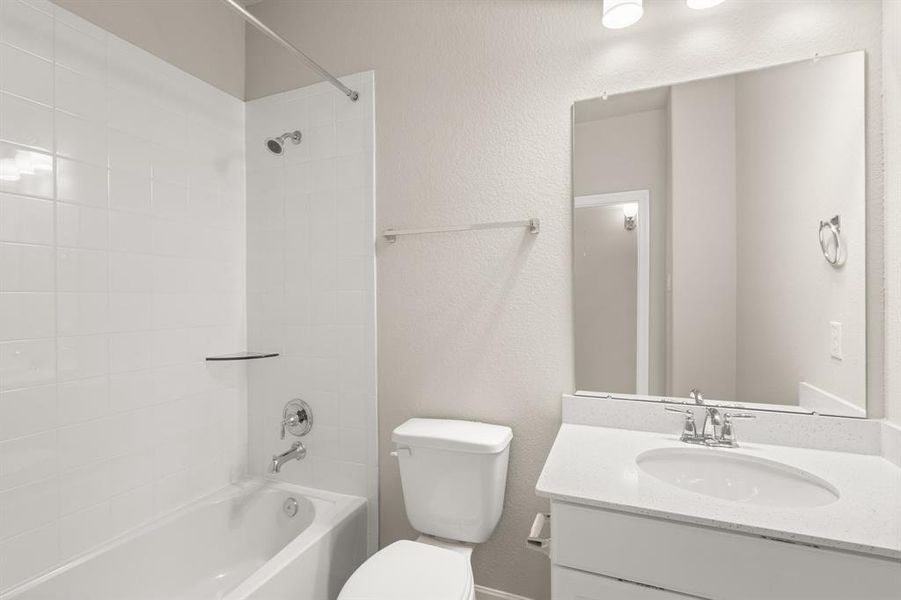 The secondary bath features tile flooring, white cabinetry and light countertops and a shower/tub combo. Perfect for accommodating any visiting family and friends.