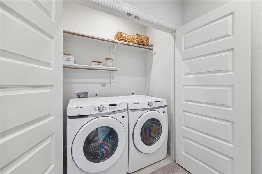 This convenient washer and dryer closet offers ample storage with built-in shelving, creating an efficient space for laundry needs. Neatly tucked away behind double doors, it maximizes functionality without compromising on style.