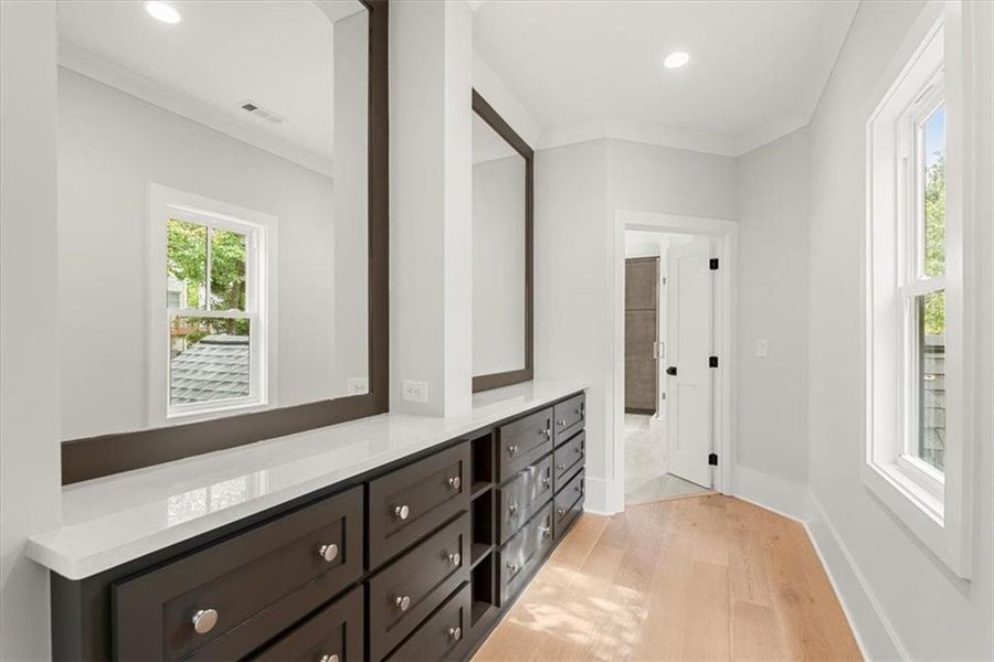 Bathroom featuring hardwood / wood-style flooring, crown molding, and vanity