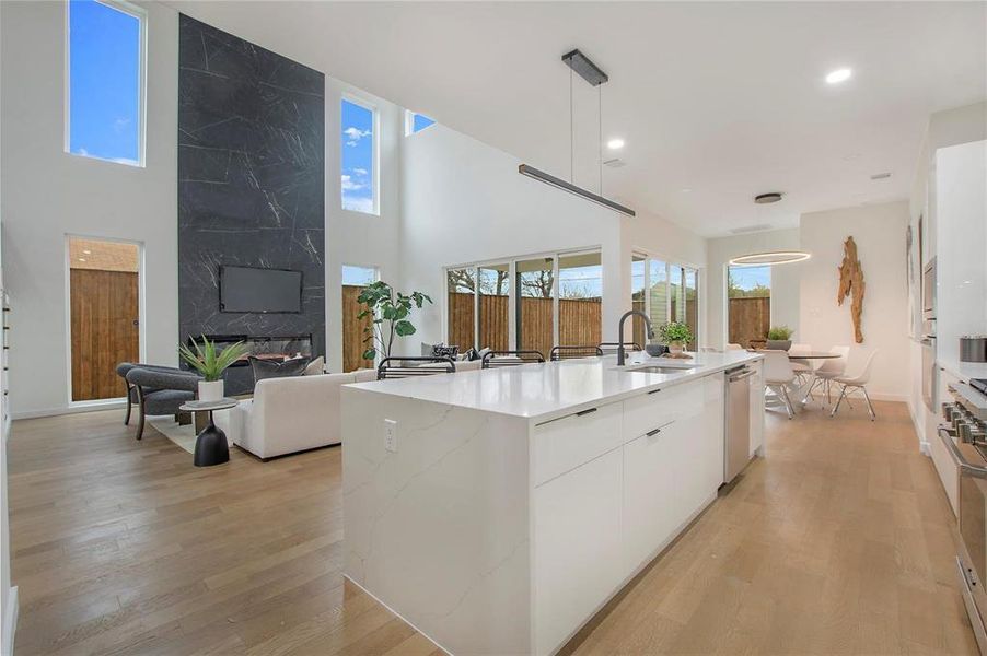 Kitchen featuring white cabinetry, stainless steel appliances, an island with sink, and plenty of natural light