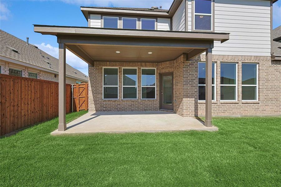 Back of house with a patio and a yard