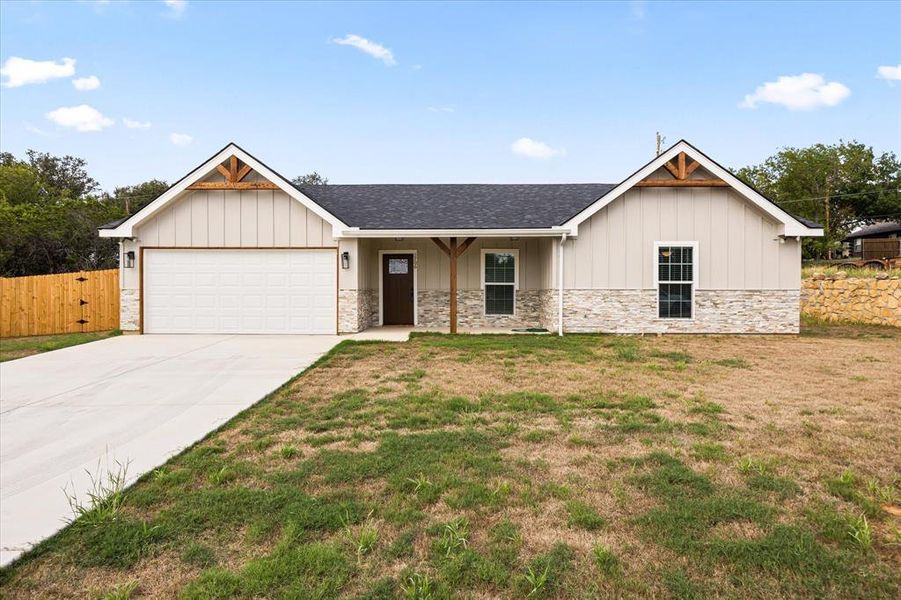 View of front of house featuring a garage and a front lawn