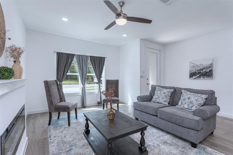 Living room featuring ceiling fan and light hardwood / wood-style flooring