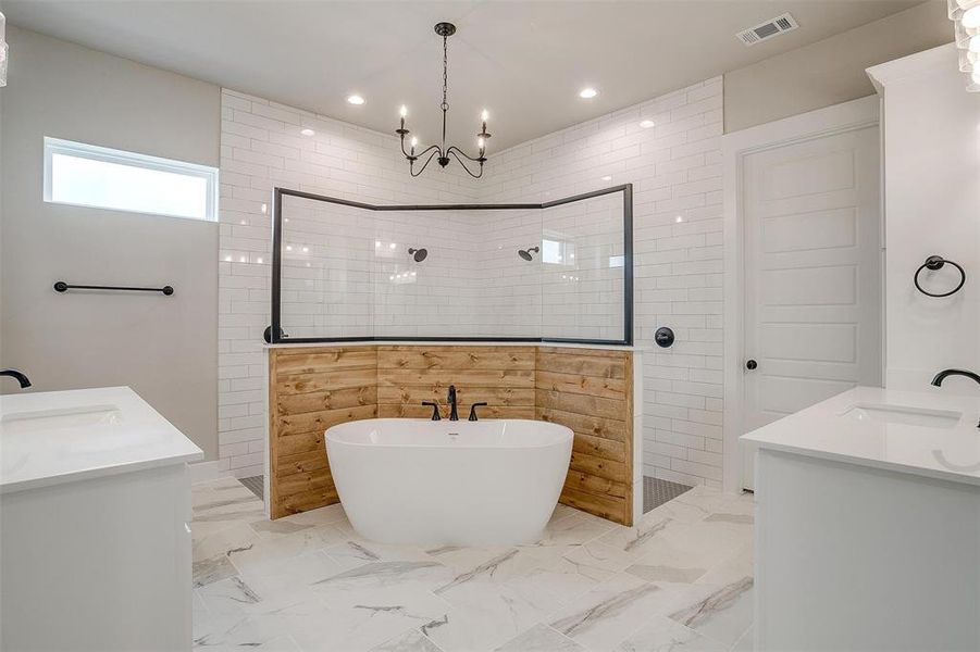 Bathroom with dual bowl vanity, tile flooring, an inviting chandelier, and independent shower and bath