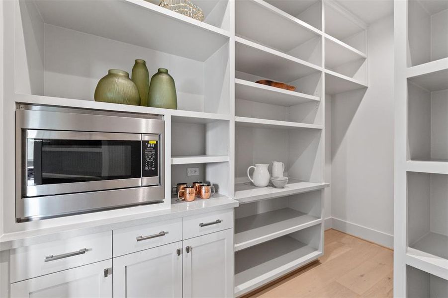 Custom walk-in closet with beverage area in primary.