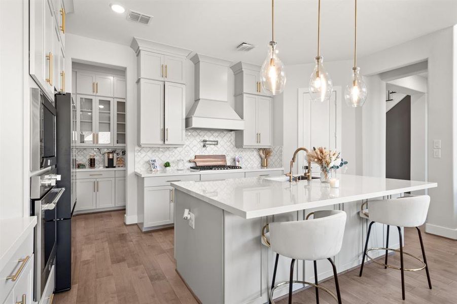 The kitchen is equipped with a large kitchen island, ample cabinet space, and a dedicated coffee area, combining functionality with convenience for culinary activities and relaxation.