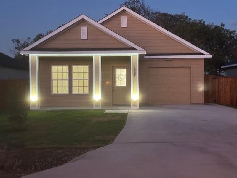 View of front of home featuring a garage and a front lawn