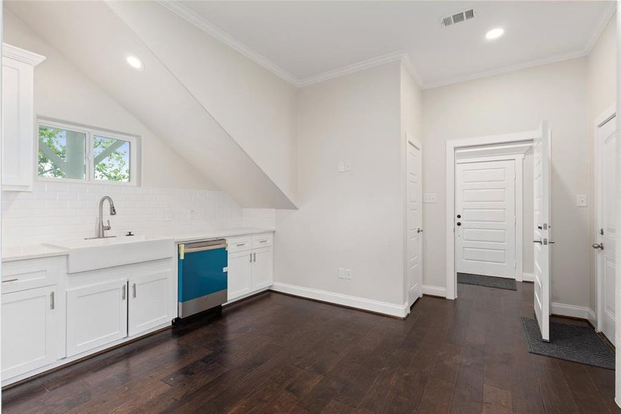 Downstairs kitchen area with farm house sink.  Two doors lead to exterior of the home and one door to close off for privacy from upstairs living area