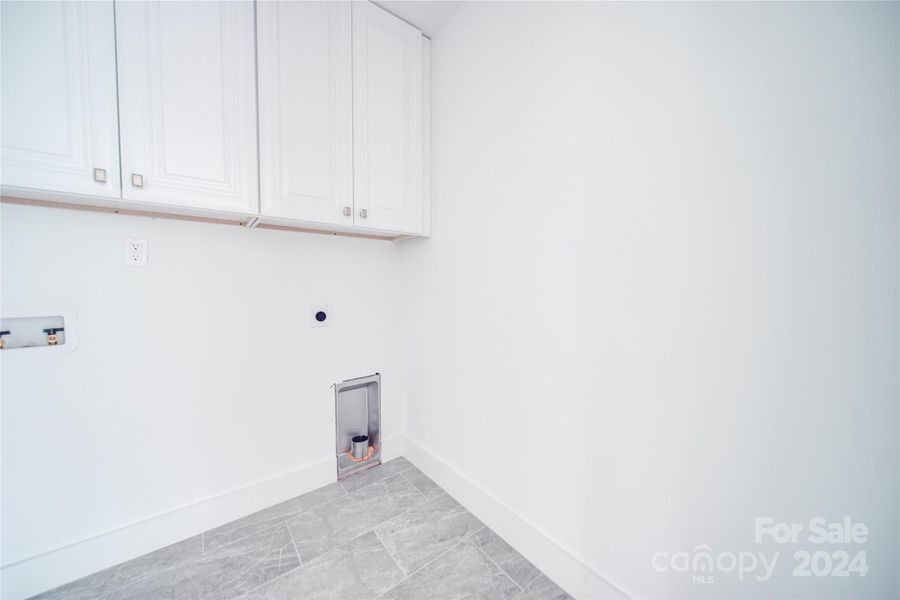 WALK IN OVER-SIZED 2ND FLOOR LAUNDRY ROOM COMPLETED WITH CABINETS ABOVE WASHER/DRYER AREA