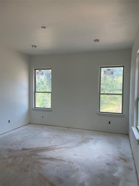 Empty room featuring concrete flooring and a wealth of natural light