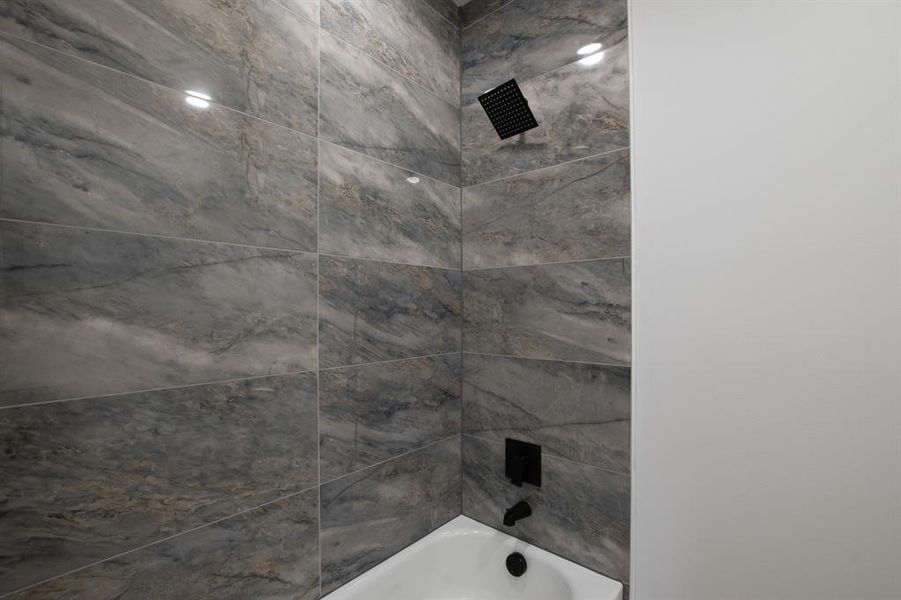 Bathroom featuring toilet, vanity, and tiled shower