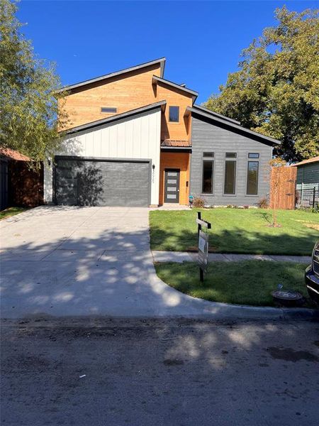 Contemporary house with a garage and a front yard