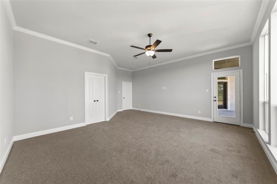 Carpeted spare room featuring crown molding and ceiling fan