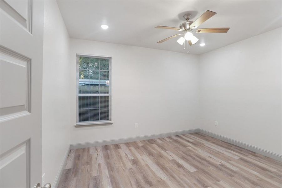 Empty room with ceiling fan and light hardwood / wood-style flooring