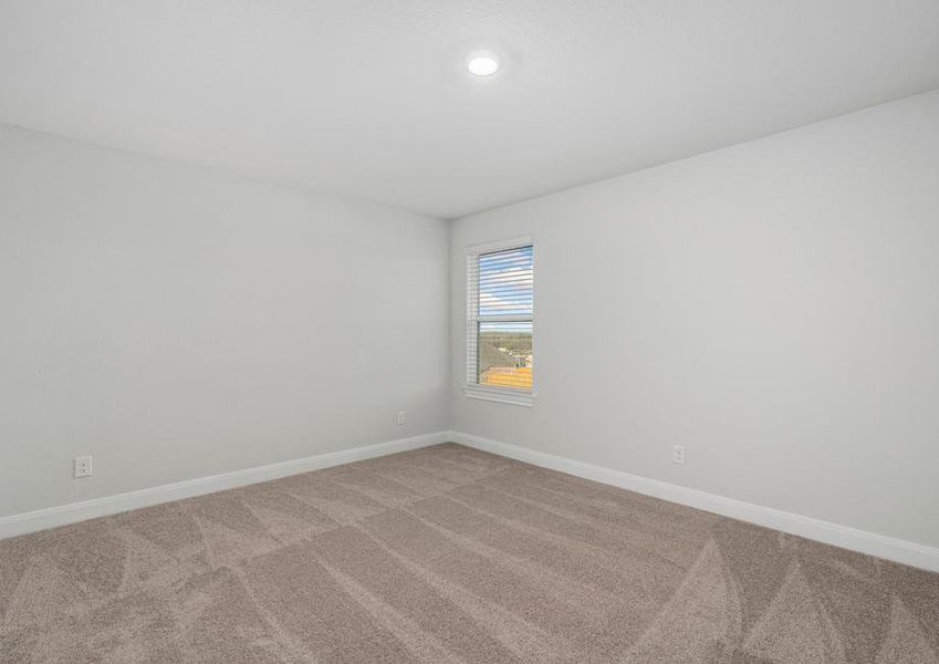 Secondary bedroom with single window and tan carpet.