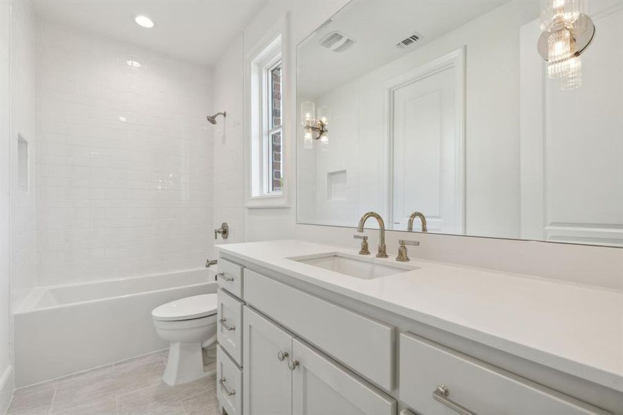 Full bathroom featuring tiled shower / bath, vanity, and toilet