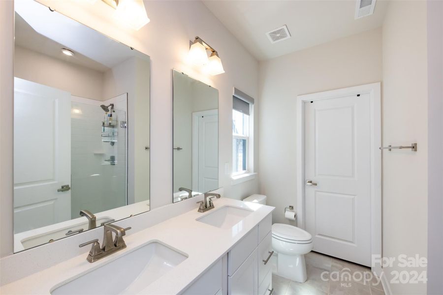 Double vanity and shower with tile surround