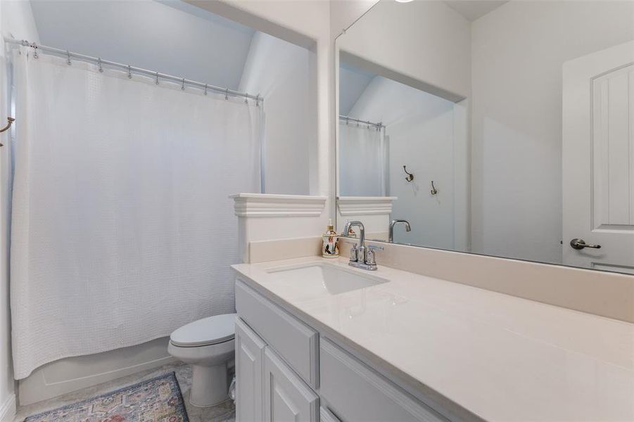 Full bathroom featuring vanity, shower / bath combo  and toilet