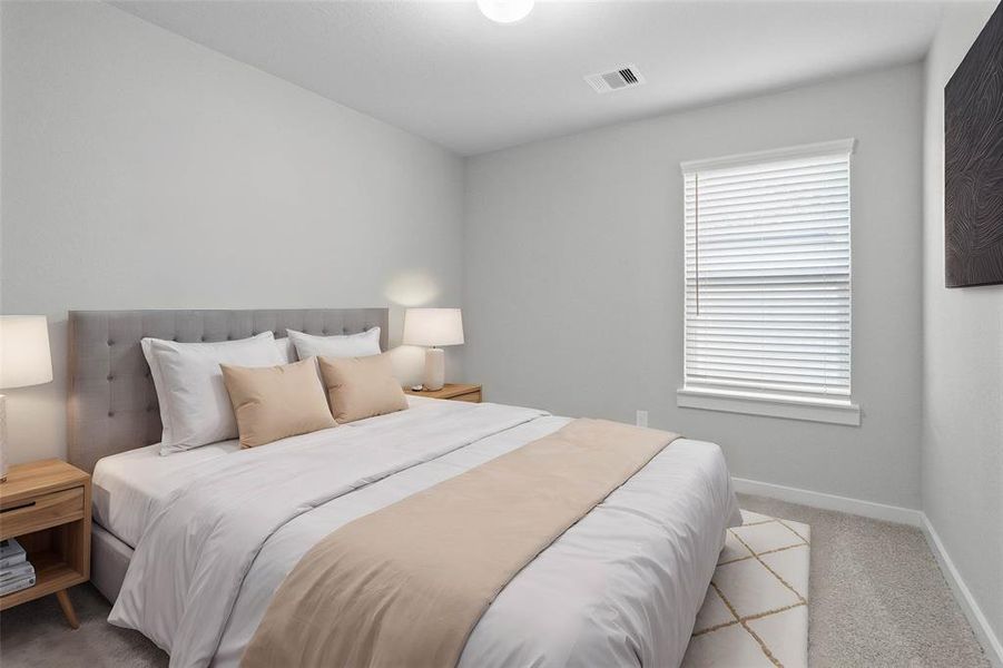 Secondary bedroom features plush carpet, custom paint, lighting, and a large window with privacy blinds.