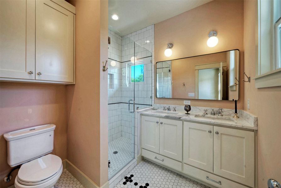 Wonderfully designed and stylish primary bath with double vanity, beautiful tile, and walk-in closet.