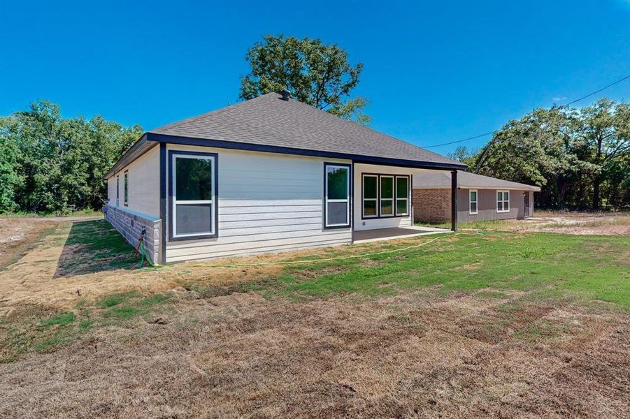 Rear view of property featuring a lawn