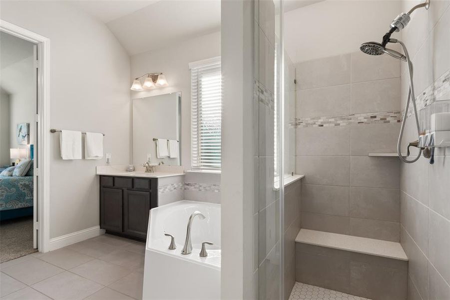 Step into serenity with this elegant en-suite, featuring a luxurious soaking tub and a sleek, tiled walk-in shower.