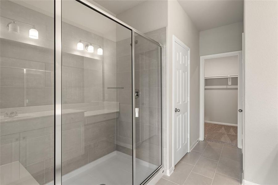 This additional view of your primary bathroom features tile flooring, fresh paint, Large walk-in shower, and a large walk-in closet.