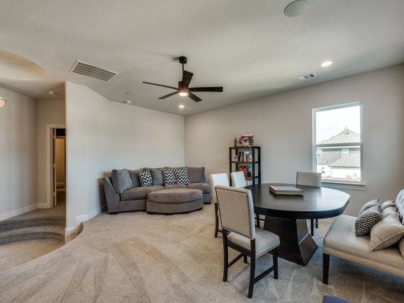 Dining room with ceiling fan, carpet, and a textured ceiling