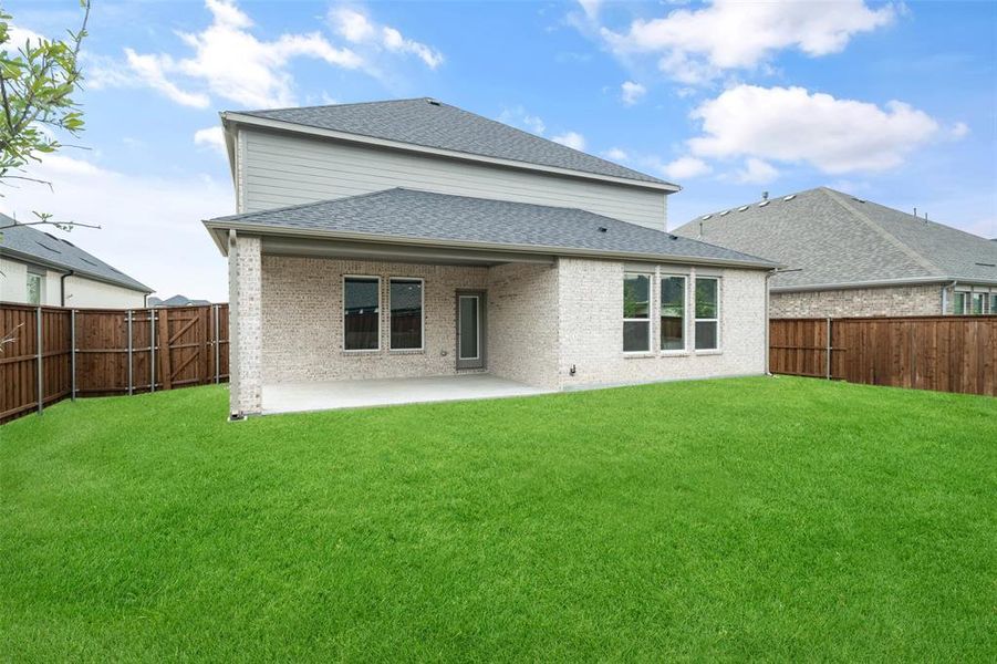 Back of house with a yard and a patio