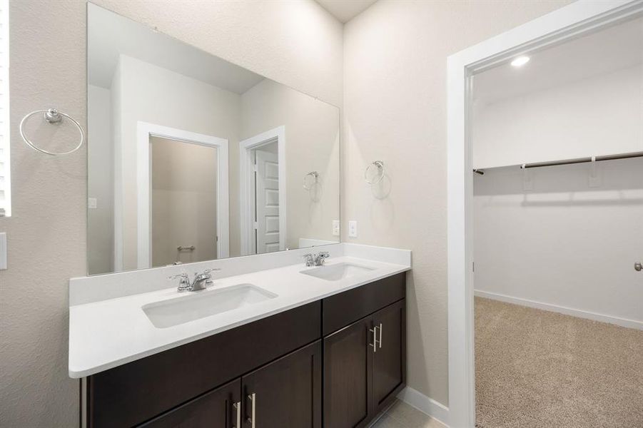 This primary bathroom is definitely move-in ready! Featuring a spa like walk-in shower with tile surround, dark cabinets with Quartz countertops, spacious walk-in closet with shelving, high ceilings, neutral paint, sleek and modern finishes.