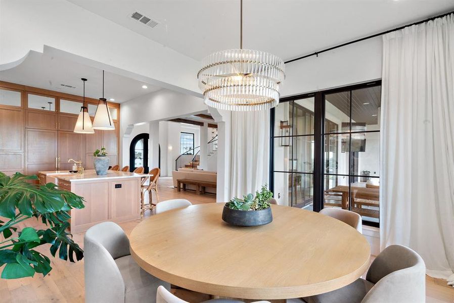 Dining space with light wood-type flooring and a chandelier