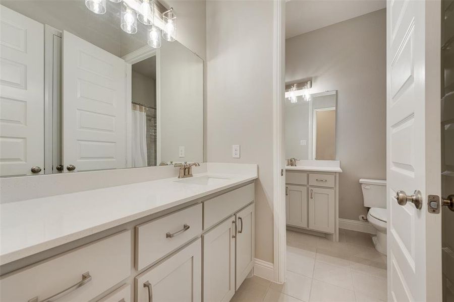 Bathroom featuring tile patterned floors, vanity, and toilet