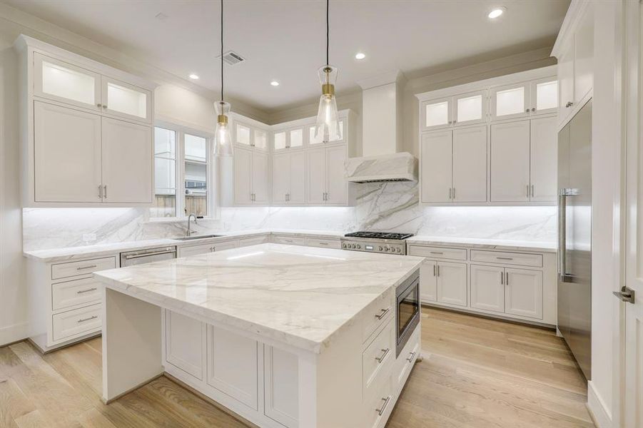 Light and bright,  this kitchen features plenty of storage options!!! Stainless appliances, side by side refrigerator and freezer,  spacious pantry and magnificent marble!!!!