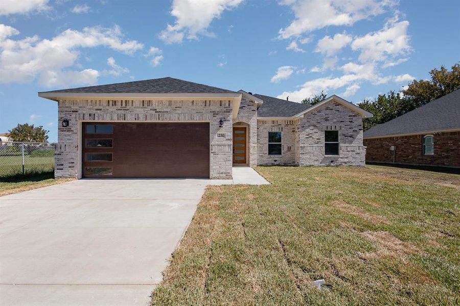 View of front of house featuring a front yard and a garage