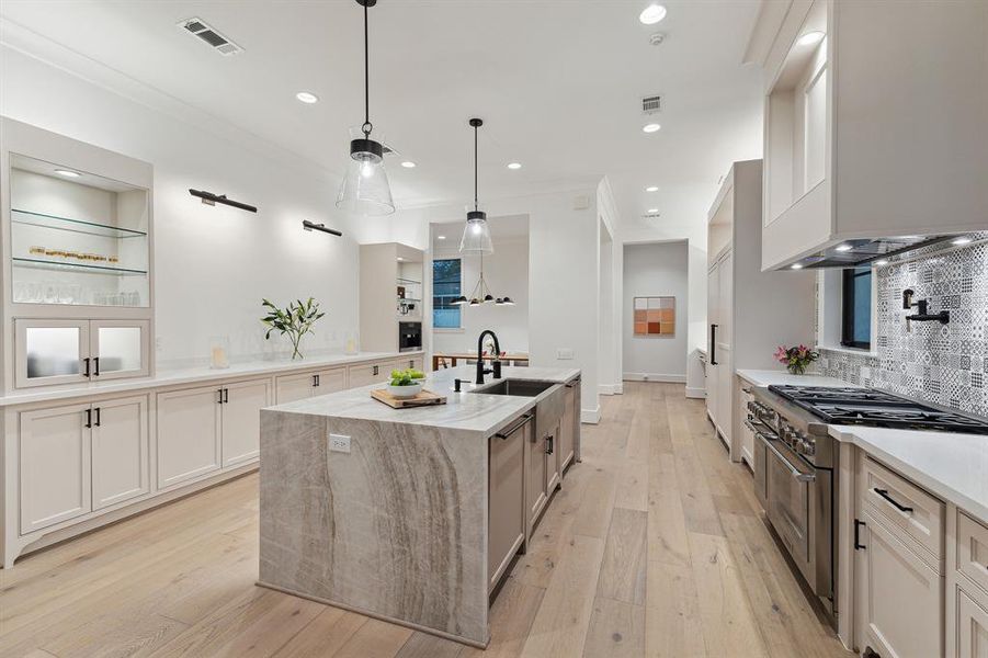 Another view of the kitchen featuring custom-built cabinets with soft-closing drawer slides by Benedettini Cabinetry, a spacious walk-in pantry, and dual Thermador dishwashers.