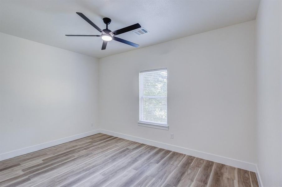 Unfurnished room featuring light wood-type flooring and ceiling fan