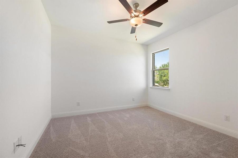 Carpeted empty room with ceiling fan