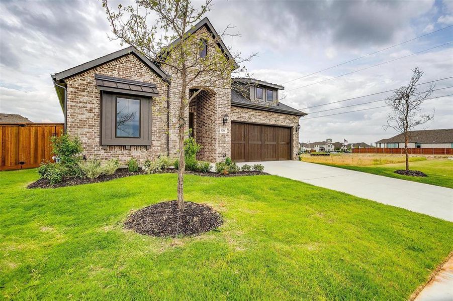 View of front of house featuring a garage and a front lawn