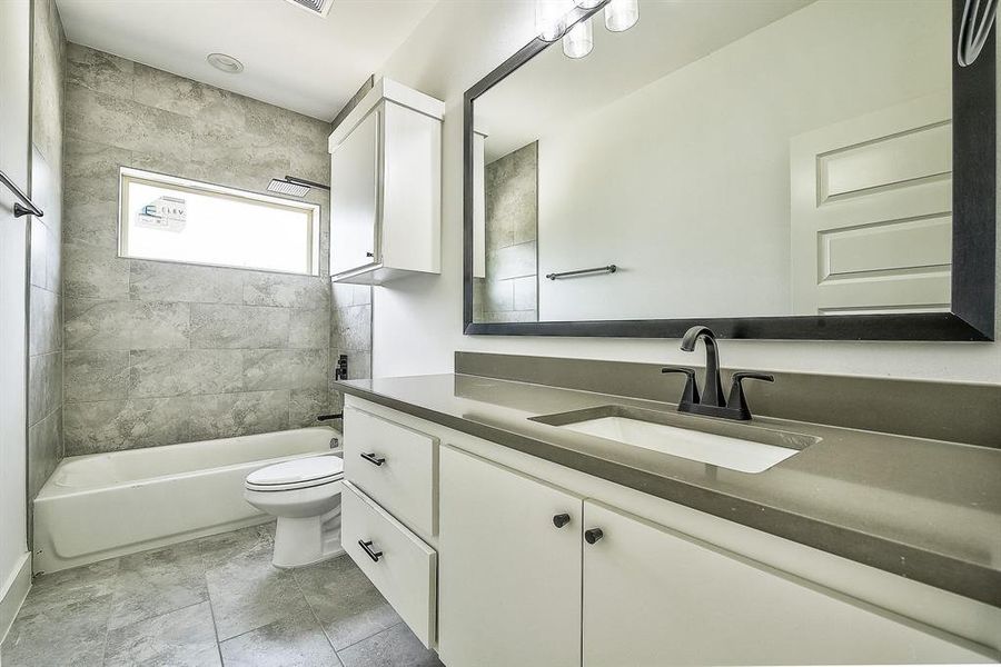 Full bathroom with tiled shower / bath, toilet, and vanity