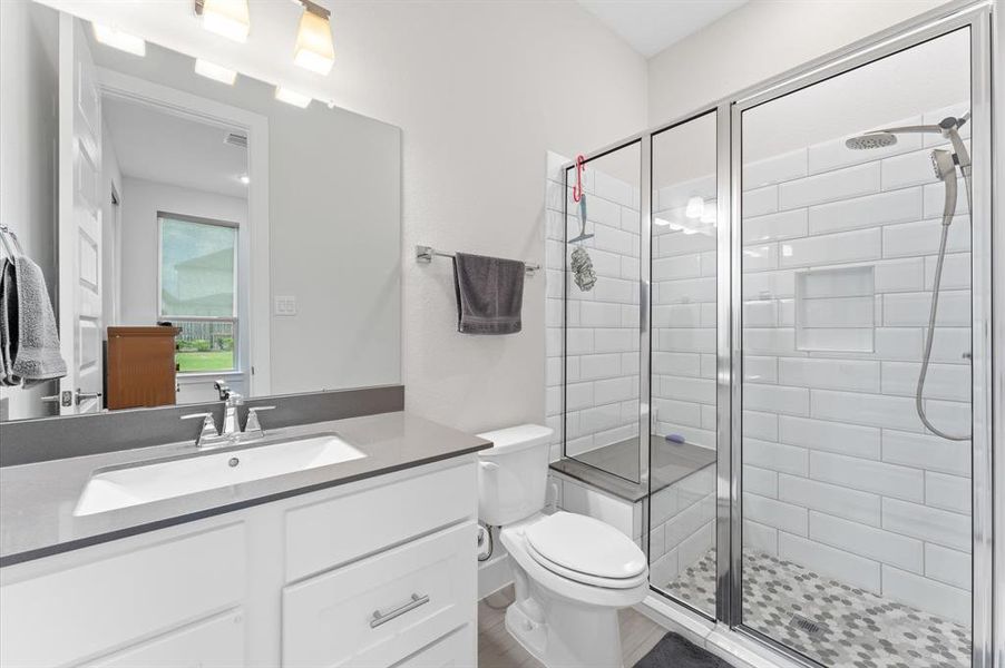 The en suite bathroom is equipped with stylish finishes and provides both convenience for guests or family members.