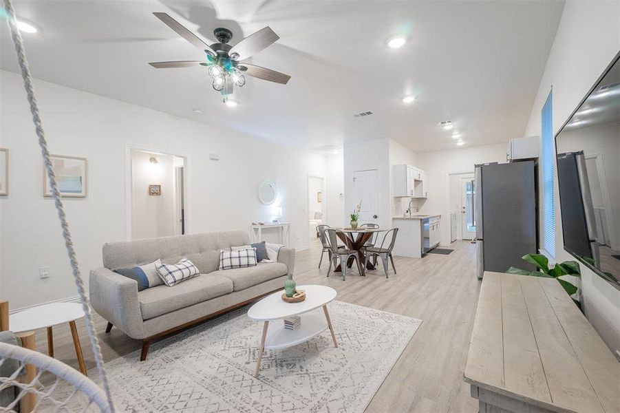 Living room featuring ceiling fan, light hardwood / wood-style flooring, and sink