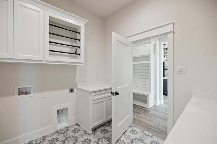 Laundry area with washer hookup, hookup for an electric dryer, light hardwood / wood-style flooring, and cabinets