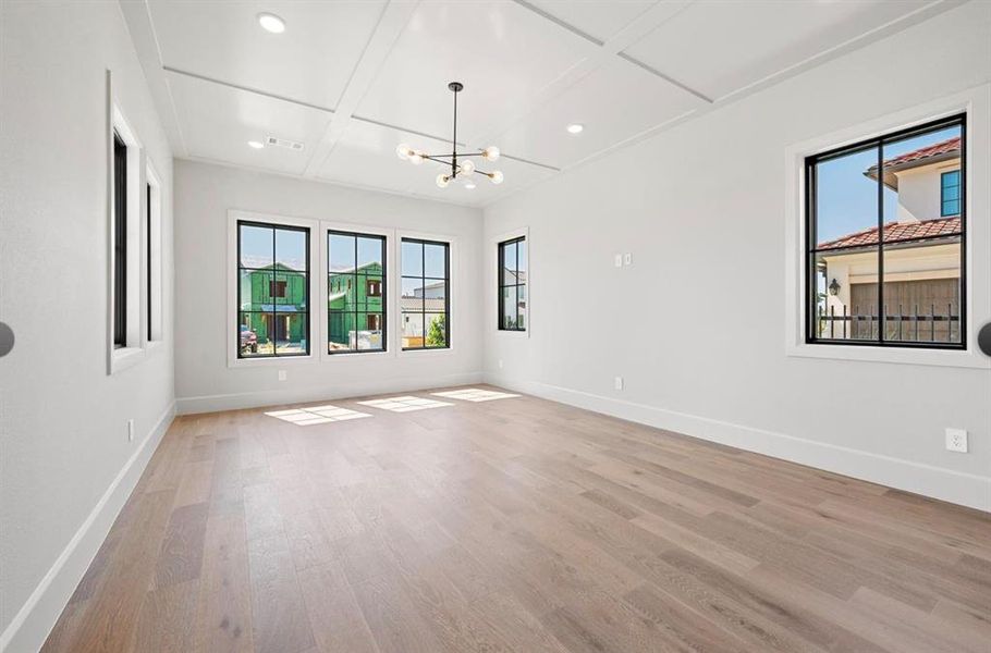 room with coffered ceiling, a notable chandelier, and light hardwood / wood-style floors