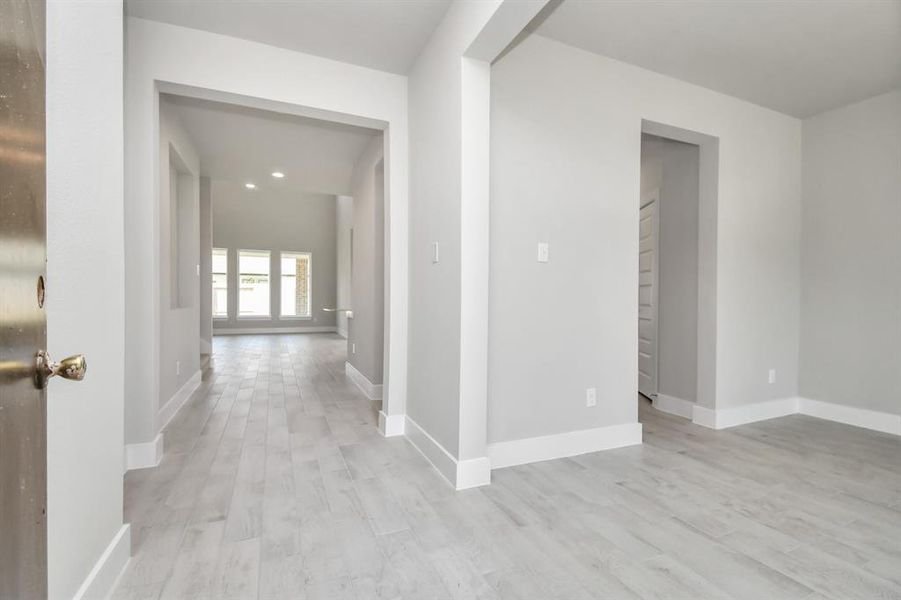 Indulge in luxury as you step into the threshold of this breathtaking home. The grand entrance beckons with its glass door, soaring ceilings, adorned with elegant wood-look tile flooring featuring sleek oversized baseboards.