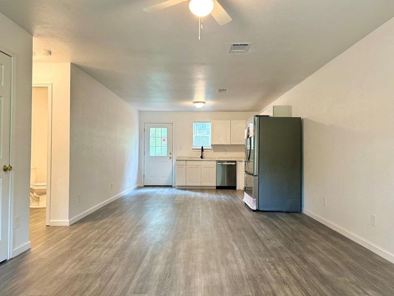 Unfurnished living room featuring sink, dark hardwood / wood-style floors, and ceiling fan